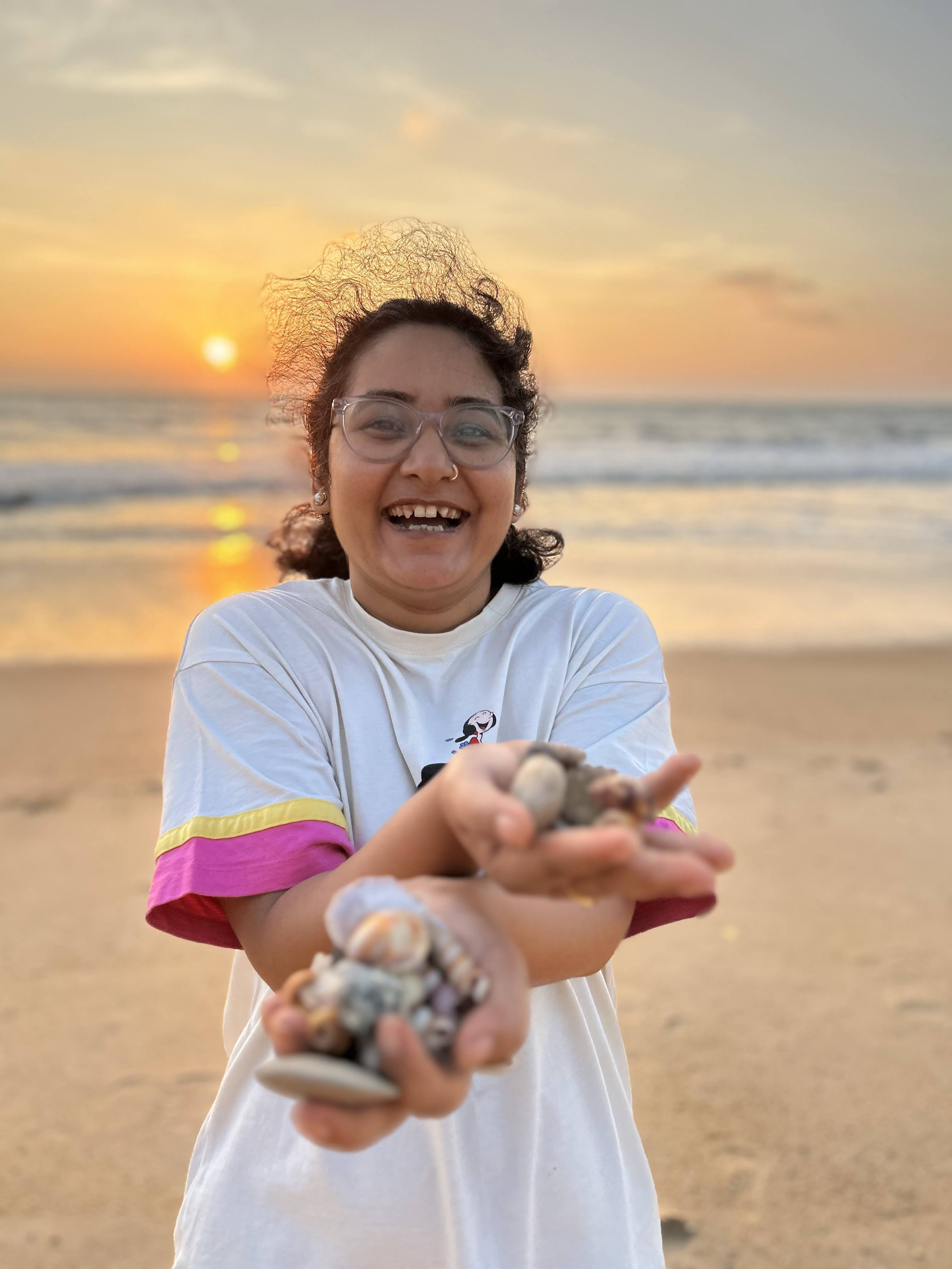 me with seashells in hand backdrop is sunset and beach